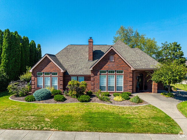 This home has a stunning cottage style design in red brick and a perfect front lawn.