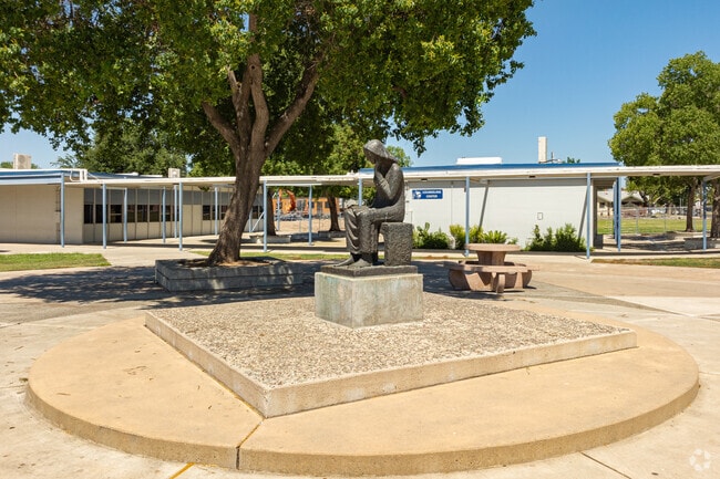 A statue of a woman sits at the center of the Woodrow Wilson Junior High School courtyard.