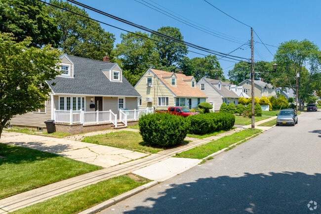 Side-gabled craftsman homes, with well-manicured lawns in New Cassel.