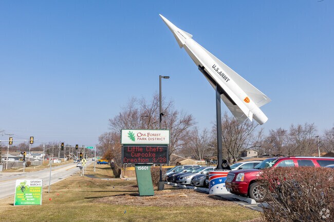 The Central Park sign in Oak Park sits near a large statue of a military jet.