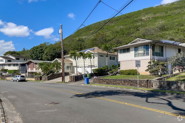 A row of two-story homes in the Moanalua neighborhood with mountains in their backyards.