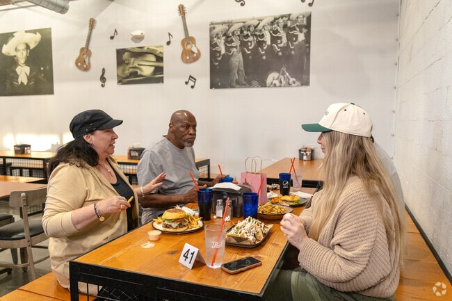 A group of people eating burgers and tacos at Sabores.