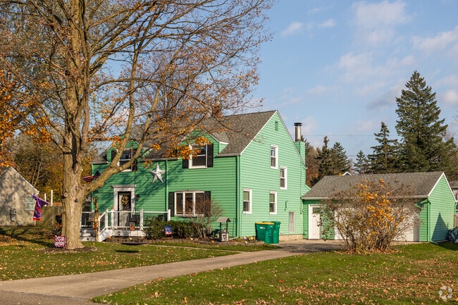 This modern green home features asymmetrically placed windows.