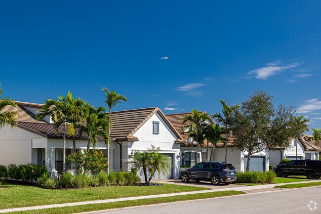 Camden Lakes homes feature two-car garages and tropical landscaping.