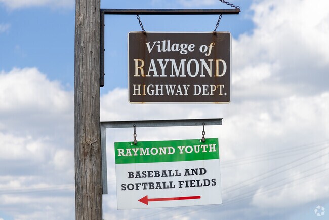 Raymond signage marks the entrance to a quiet community with large lots and hobby farms.
