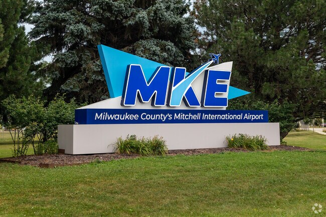 The sign in front of Milwaukee Mitchell International Airport is surrounded by green space.