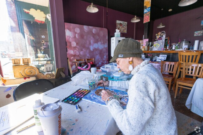 Paula Kay, an artist at Dancing Wind Studio, near Deering, paints a canvas.