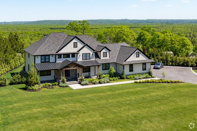 This Montville home combines the exposed beams of Craftsman style with farmhouse metal roofing.