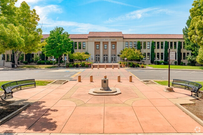 Students gather at the front of McClatchy High and mingle after school on benches.