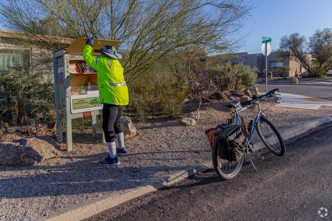 A bicyclist stops at the Little Free Library on Blacklidge Drive in Cabrini.