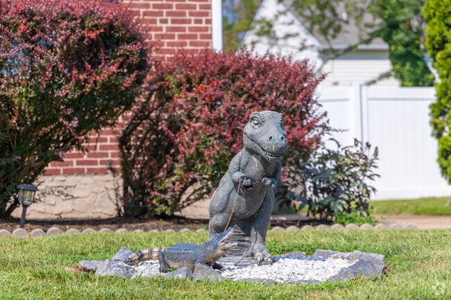 A fun dinosaur statue taking his alligator for a walk in Ashley.