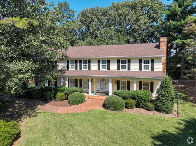 A mature two story home in New Sherwood Forest with a covered front porch