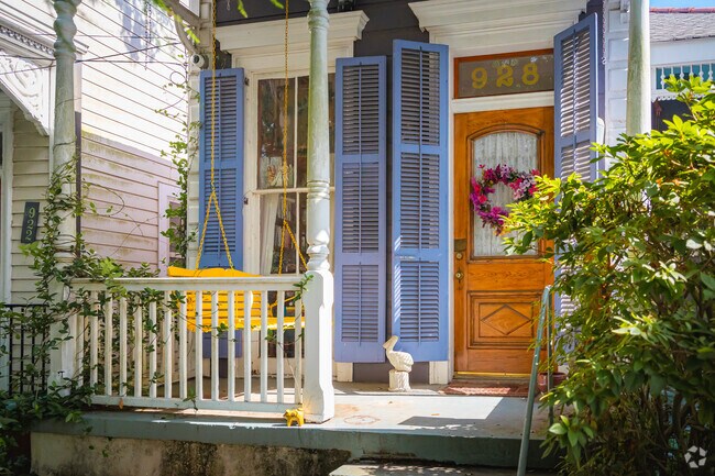 Lavender shutters and a yellow porch swing adorn this Algiers Point home.