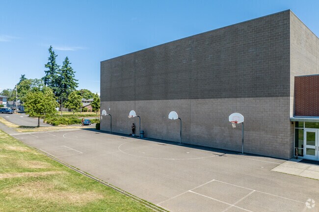 Along the back walls of Ron Russell Middle School are multiple basketball hoops.