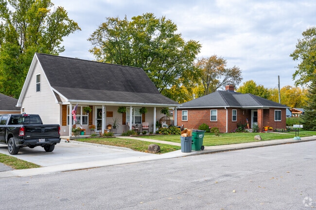 A pitched roof home next to a brick French colonial style home on Sparks St in Pittsboro.