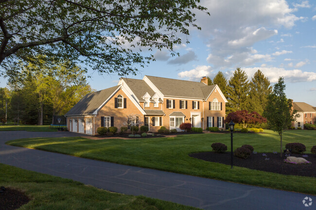 The setting sun highlights this large brick home with 3-car garage in Spring House.