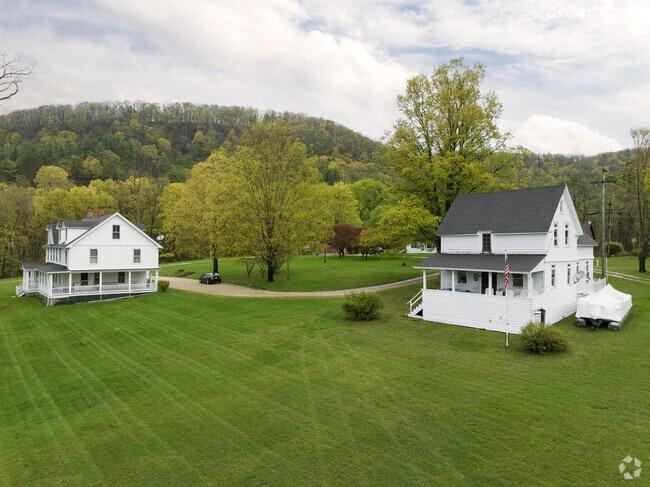 Two traditional farm houses sit looking over Lake Wononscopomuc.