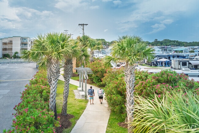 Visitors walk a lush, palm-lined pathway leading to the beach from Grande Dunes.