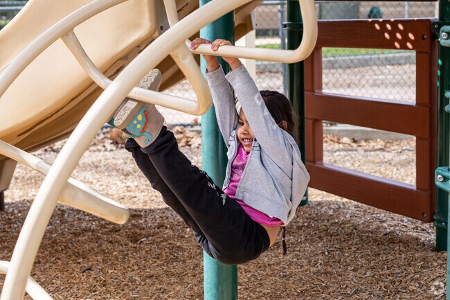 A future little gymnast shows off her skills at the playground at Acton Park in Acton.