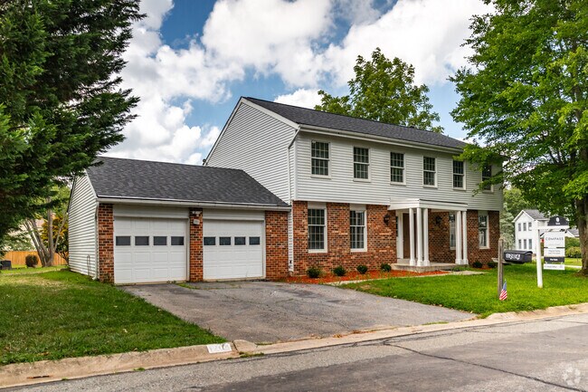 Massive colonial home for sale in Colesville, featuring brick facades and a two car garage.