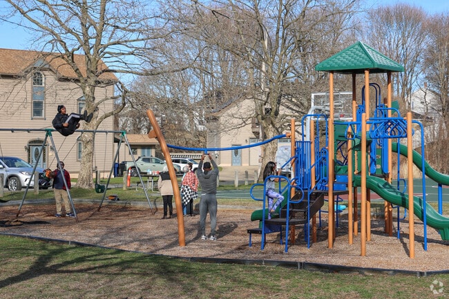 Children delight in the vibrant play structure at Castle Hill Park in the Castle Hill neighborhood, where they can swing high into the air, race down the twisting slides, and zoom across the thrilling zipline, filling the air with laughter and excitement.