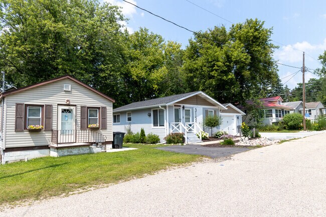 Gravel road winds past cottages on a sunny day in Como, Wisconsin.