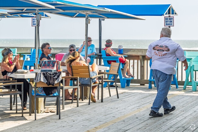 Locals relax and socialize with ocean views at a seaside deck near Grande Dunes.