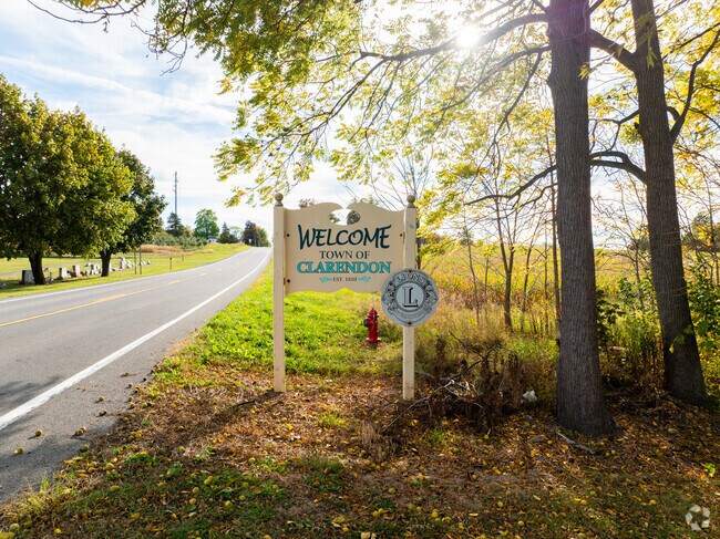 A roadside sign greets travelers entering Clarendon, marking the town’s founding in 1810.