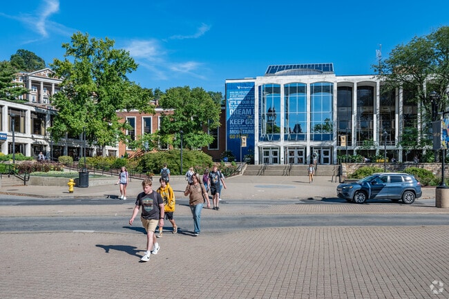 Several WVU students are crossing the street in Wiles Hill-Highland Park.