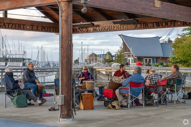 A drum circle forming community peace, at the harbor next to Cain Road.