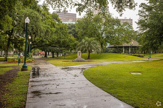 New Orleans CBD Duncan Plaza features a paved walkway along with landscaped trees & grass.