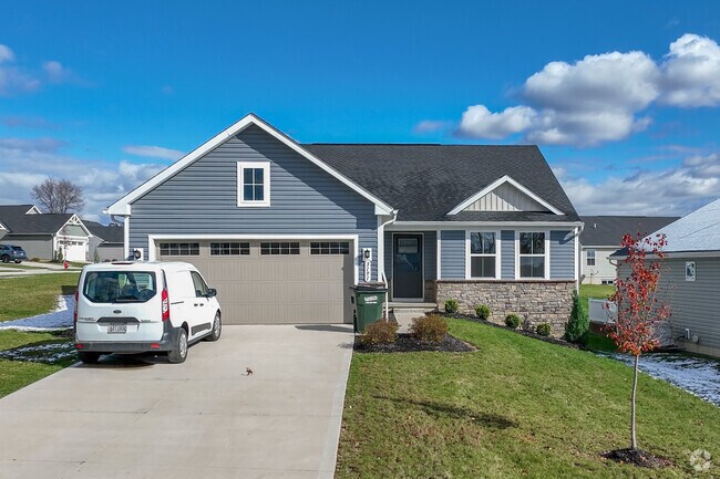 Brick Ranch style home with a tidy lawn in Lakemore.