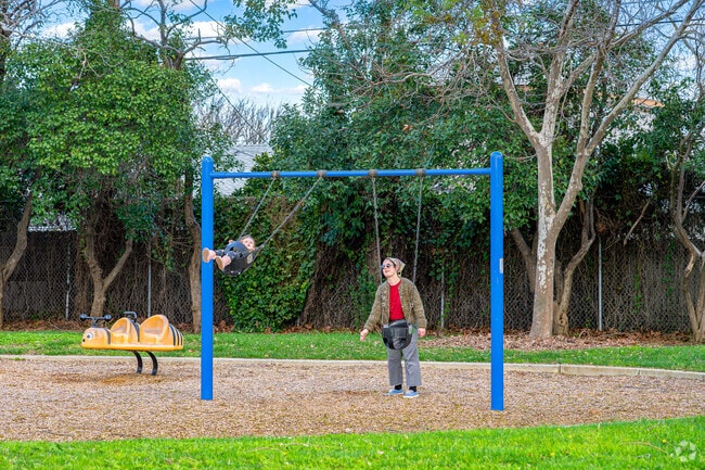 A mom pushes a baby high on the swings at Earl Warren Park near Glen Elder.