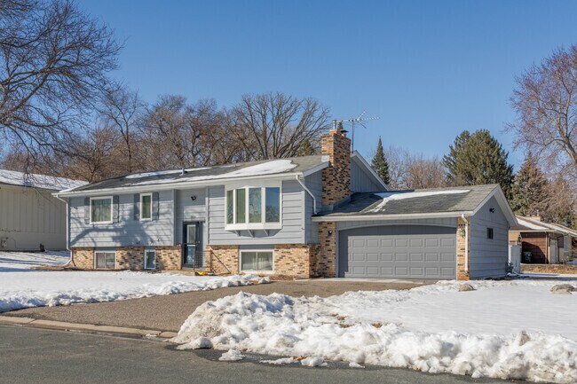 This particular split level has an attached garage and a brick facade.