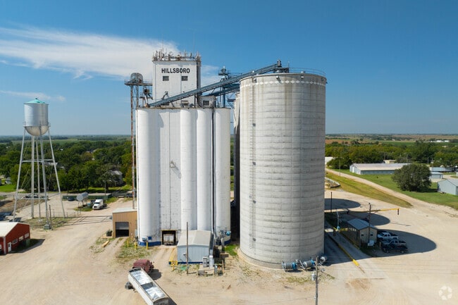 Farm equipment operates near Hillsboro, supporting wheat and livestock production.