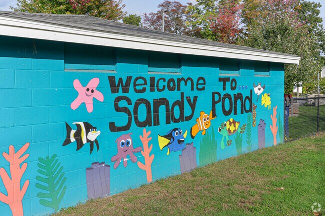 A mural painting welcoming folks to Sandy Pond, a resident-only beach access pond.