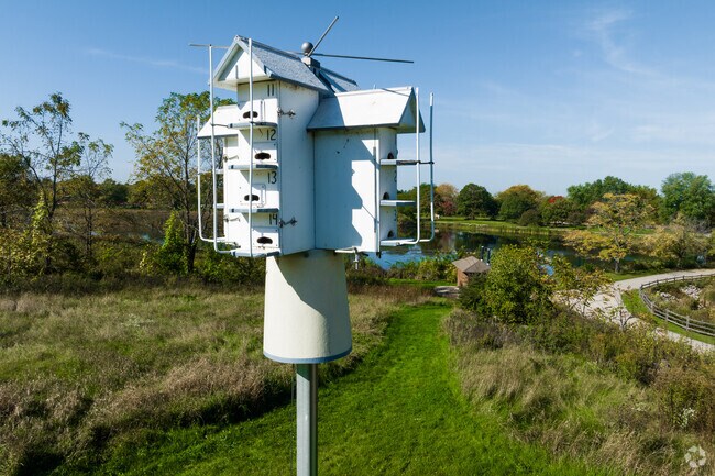 A large birdhouse in Lakewood Forest Preserve with multiple rooms featuring an overhanging roof.