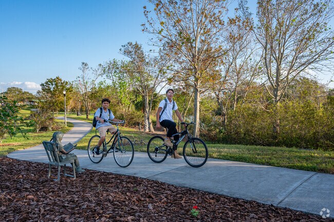 Cyclists navigate the sidewalk trail around the lake at Walter Fuller Park.