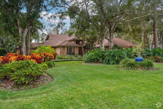 Large brick home set back on a deep lot with lakefront frontage in the Bent Tree neighborhood.