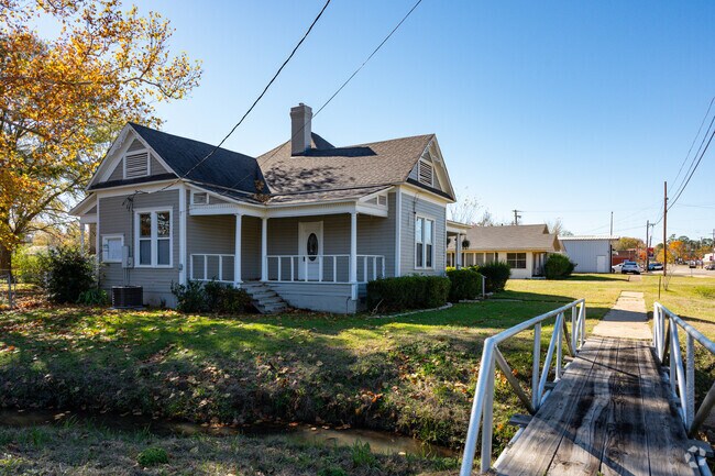 A Cape Cod inspired home sits next to a stream in Plain Dealing, Louisiana.