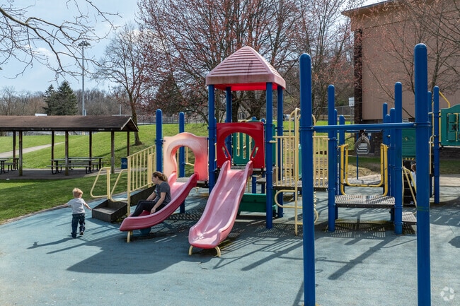 Kids play on the playground at Brookline Memorial Park.
