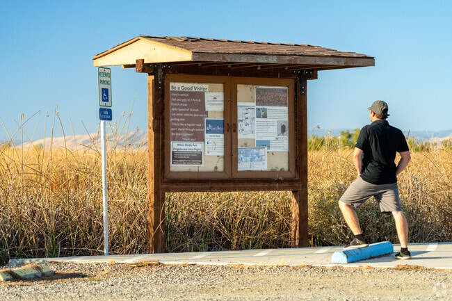 A visitor reads an informational sign at Sacramento National Wildlife Refuge.