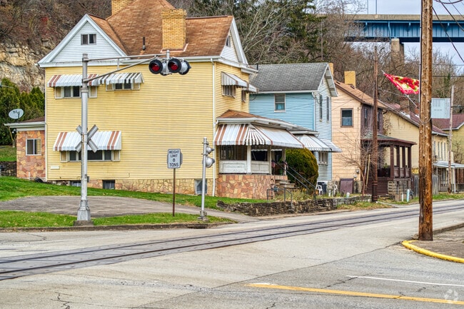Homes in West Brownsville stand along the railroad tracks near the river.