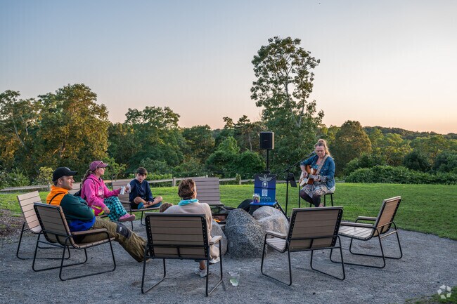 Families listen to live music as the sun sets at the Auto Camp in West Falmouth.