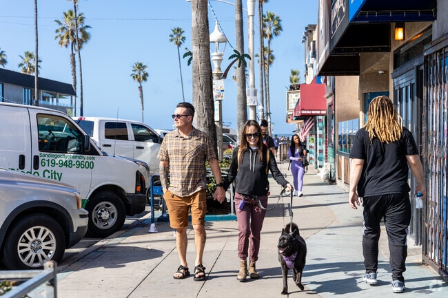 A couple enjoys a stroll along Newport Avenue where an abundance of shops are found.