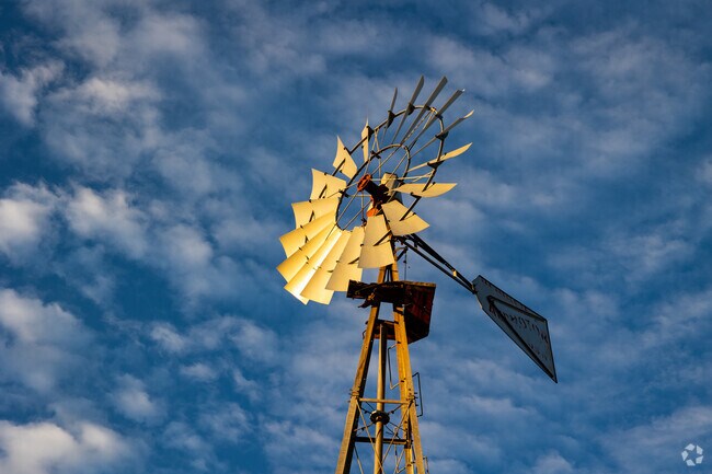 A scenic windmill and picturesque sunset sky at Stagecoach Park in Buda.