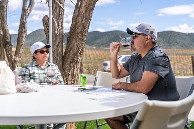 A couple sits on the patio and enjoys their wine at Reyes Winery in Agua Dulce.