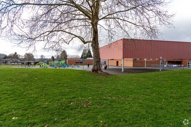 A large grassy area sits behind Hollydale Elementary School.