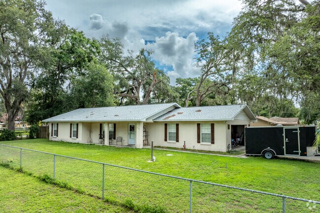 Traditional ranch-style home in Zephyrhills South sits on a fenced lot with mature oaks.