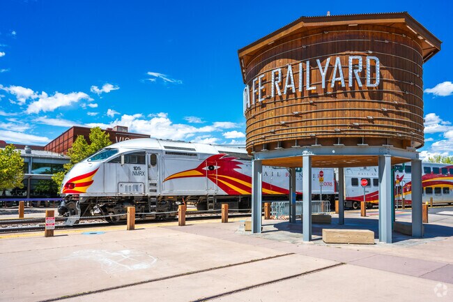 The Rail Runner train leaves station & passes the picturesque Santa Fe Railyard Water Tower.